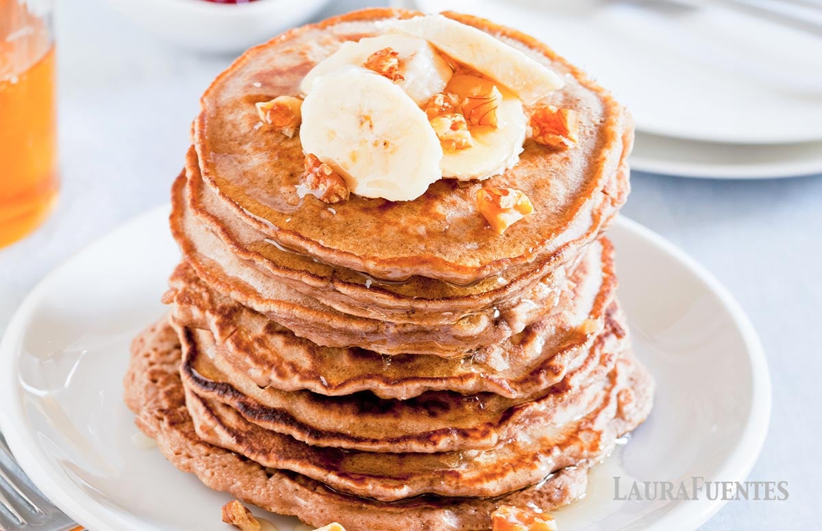 fluffy stack of whole wheat banana pancakes topped with bananas and nuts