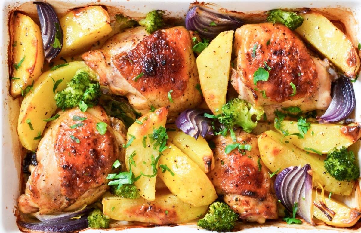 baking dish with roasted chicken pieces and potatoes