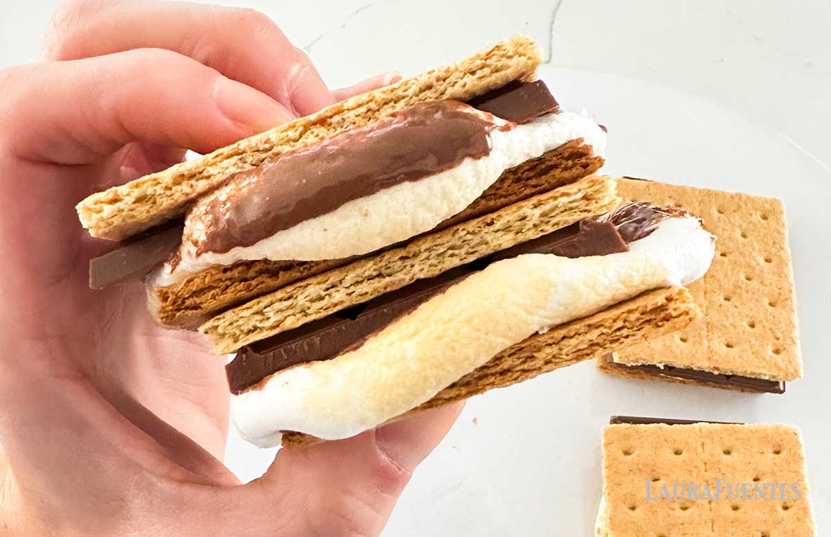 two stacked s'mores being held in a hand