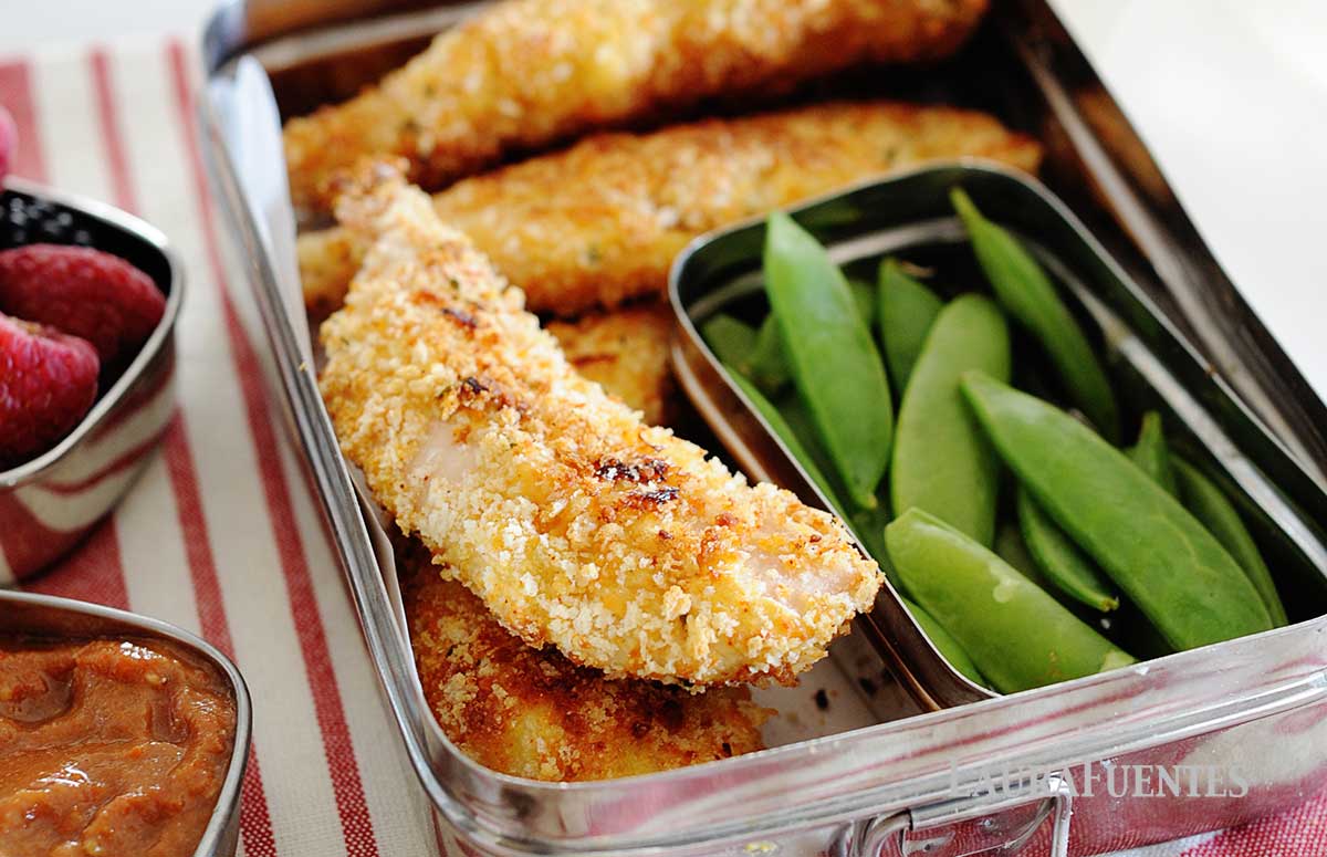 parmesan chicken tenders in a lunchbox with green peas