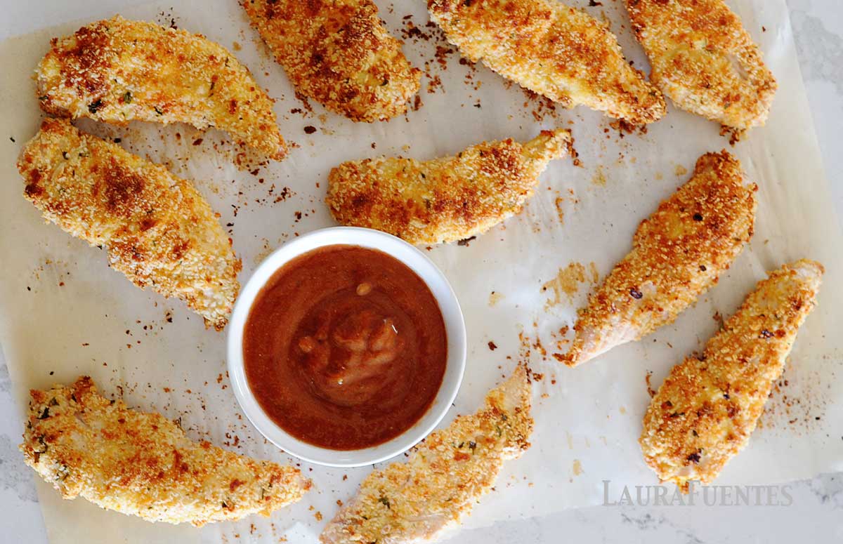 parmesan chicken tenders next to a dipping sauce