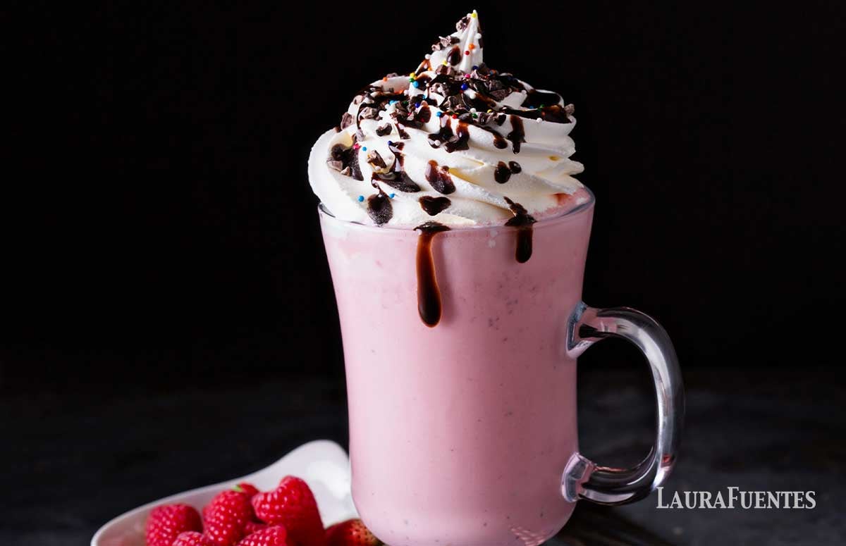 a mug with pink hot chocolate topped with whipped cream