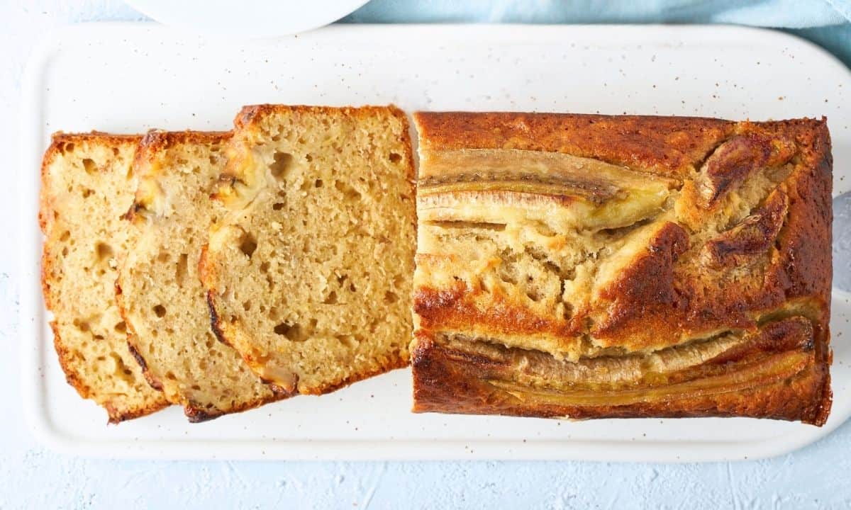 overhead view of sliced moist banana bread bread loaf on a cutting board
