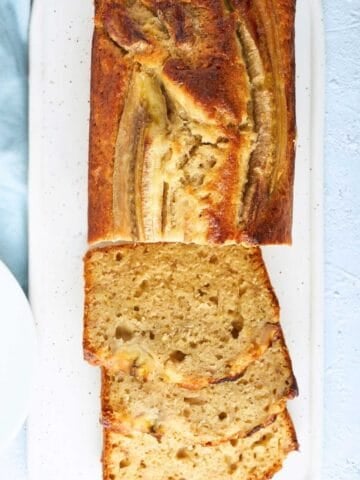 overhead view of sliced moist banana bread bread loaf on a cutting board