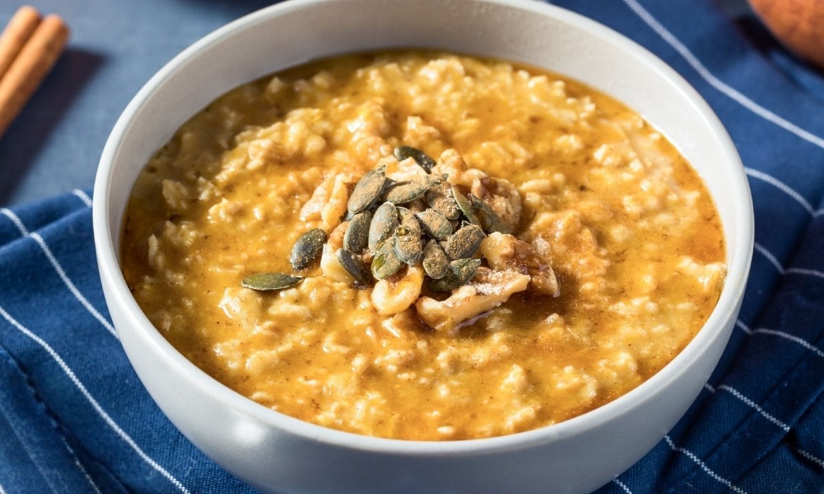 a bowl of sweet potato oatmeal topped with seeds