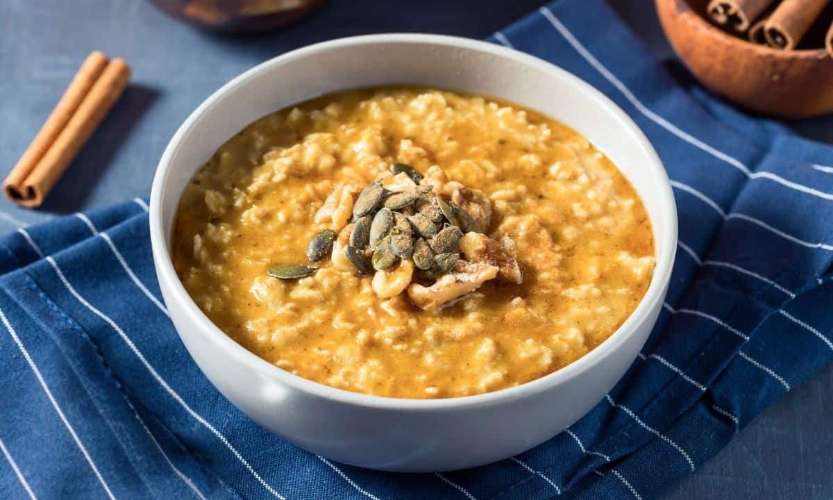 a bowl of sweet potato oatmeal topped with seeds