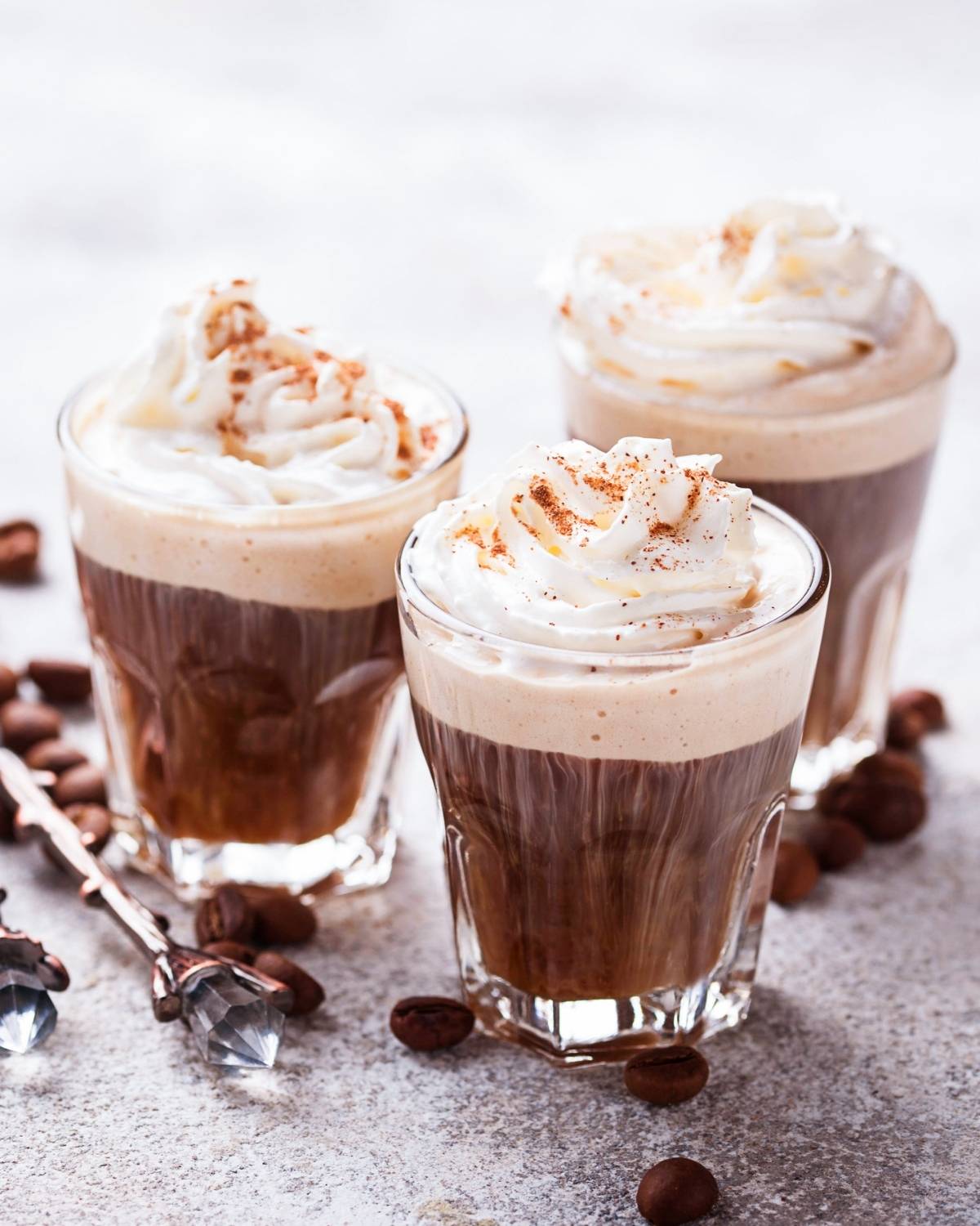 three cups of coffee hot cocoa topped with whipped cream