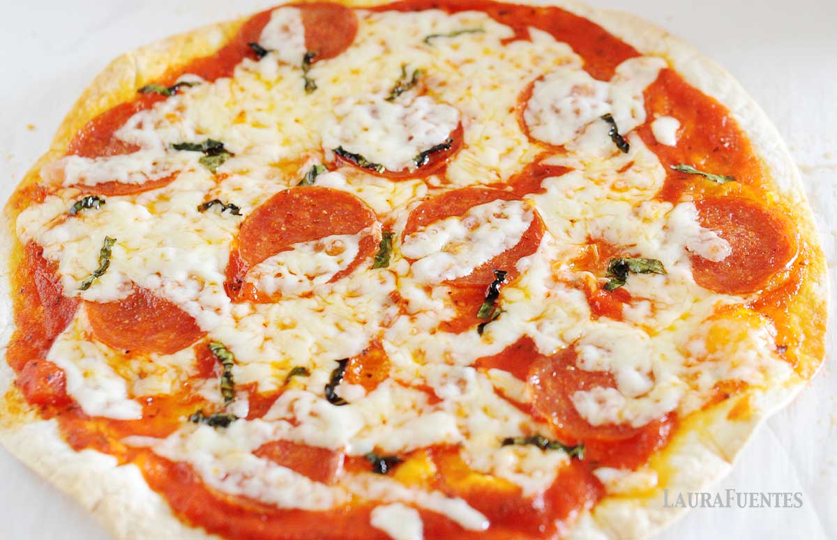 closeup of tortilla pizza with pepperoni and basil