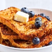 a stack of french toast topped with butter and blueberries