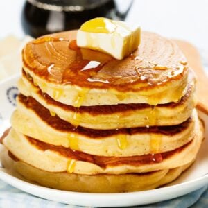 stack of homemade aunt Jemima pancakes with syrup and butter