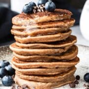 large stack of buckwheat pancakes topped with blueberries