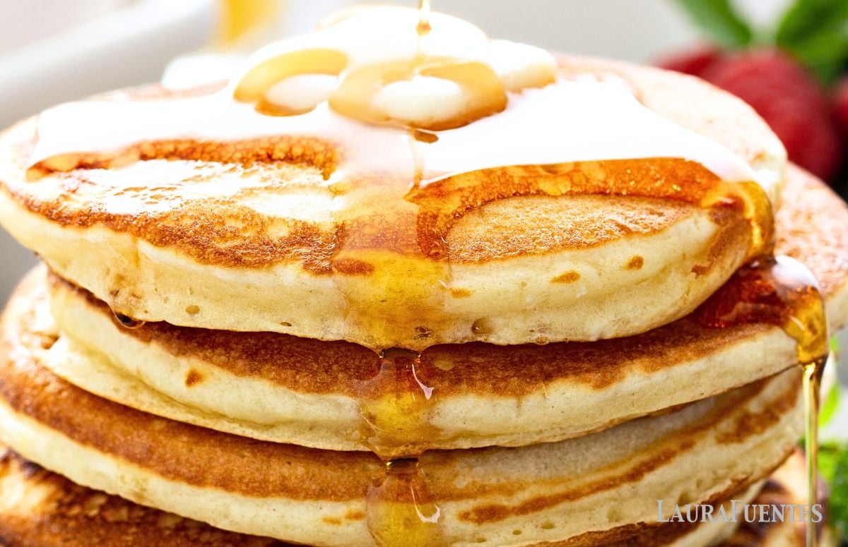 three fluffy pancakes topped with butter and syrup