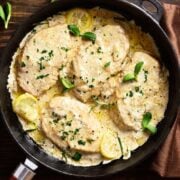 top view of a skillet with chicken breasts covered with cottage cheese sauce