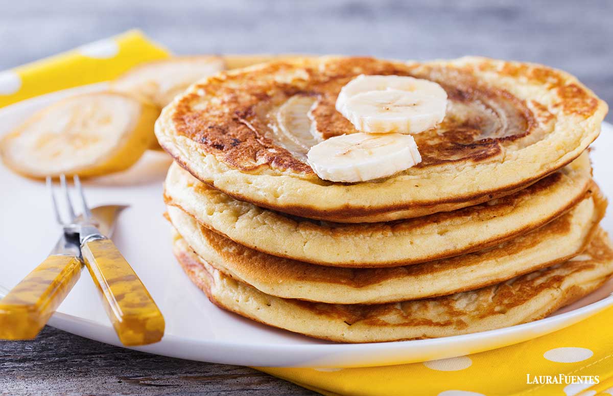 stack of banana pancakes topped with banana slices