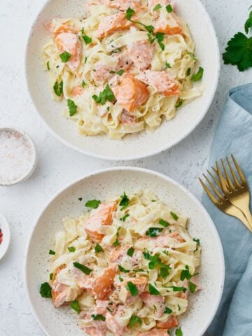 top view of two dishes of salmon alfredo