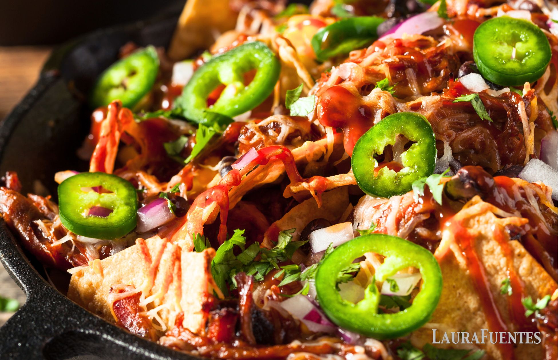 pulled pork tacos in a skillet topped with jalapeno slices

