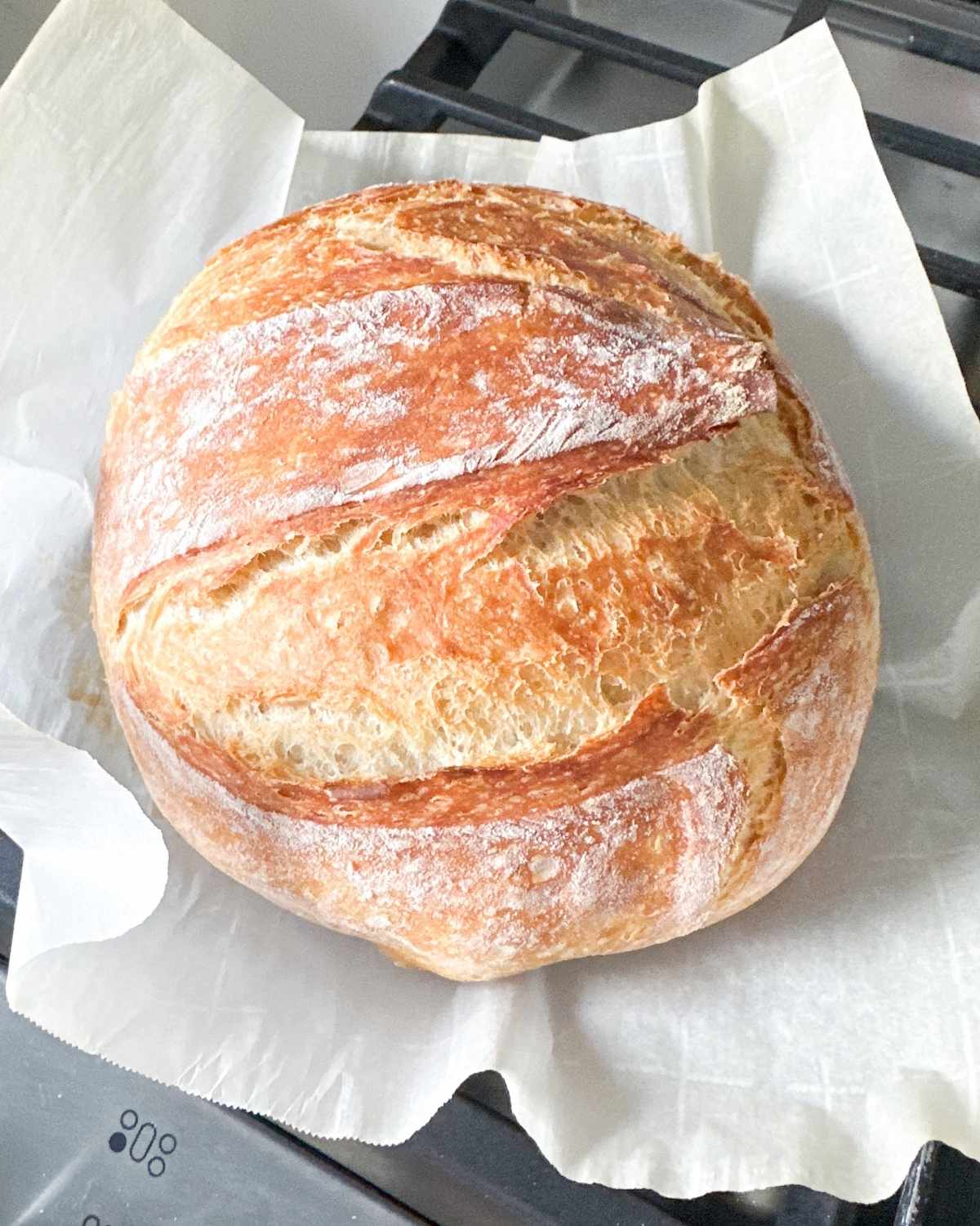 finished round loaf of bread on a parchment paper