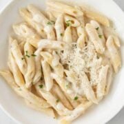 top view of pasta penne with Alfredo sauce in a white dish