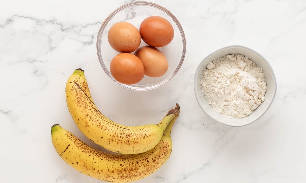 overhead view of the 3 ingredients needed to make 3-ingredient banana pancakes: bananas, flour, and eggs