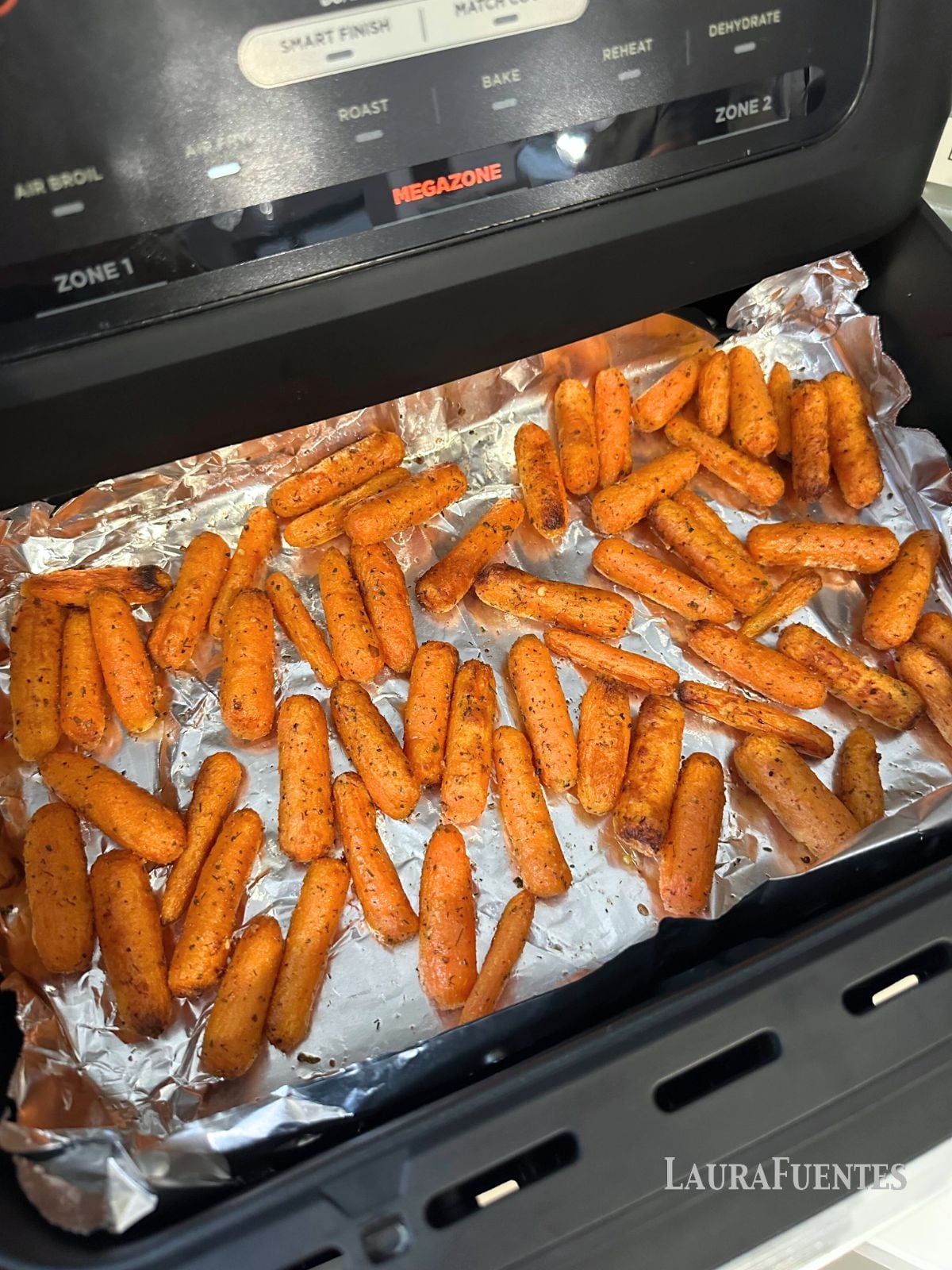 baby carrots in an air fryer lined with foil