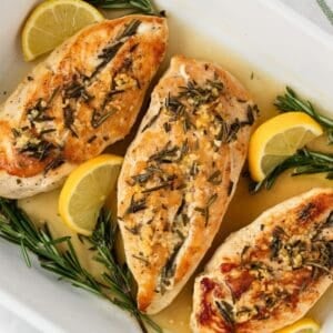 Rosemary chicken breasts in a baking dish.