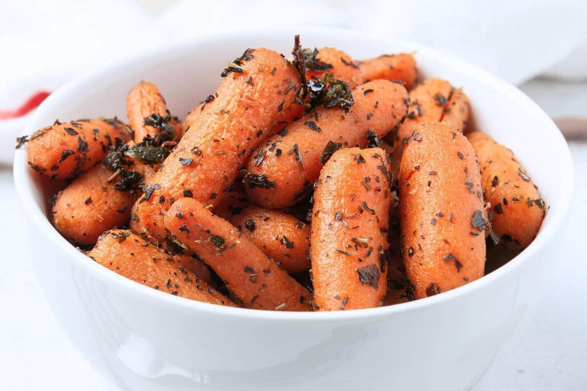 seasoned baby carrots in a white bowl