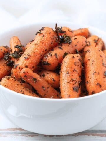 seasoned baby carrots in a white bowl