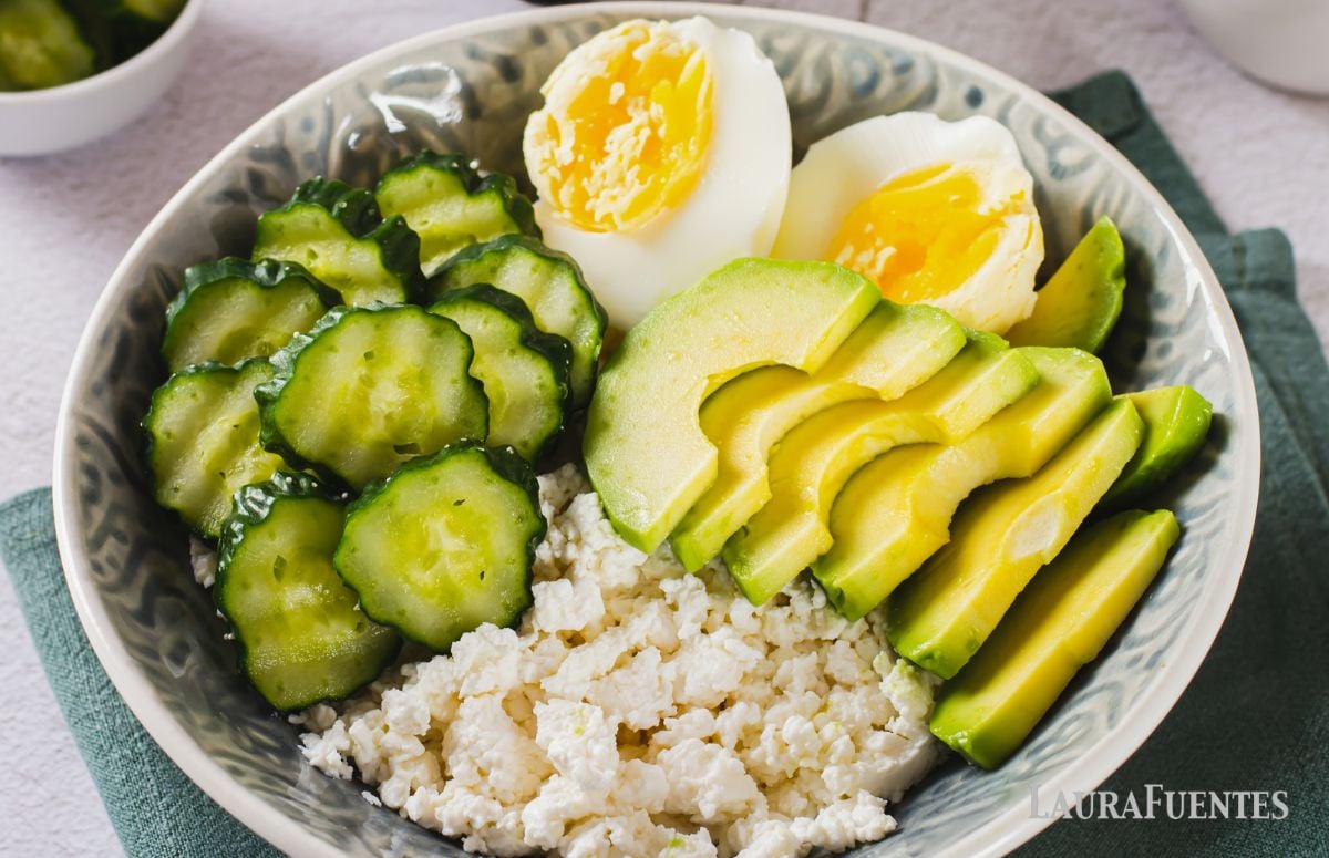 top view of breakfast bowl with cottage cheese, avocado, hard boiled egg and cucumber