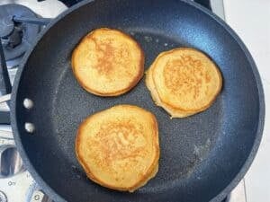 overhead view of cooking cottage cheese pumpkin pancakes on a pan
