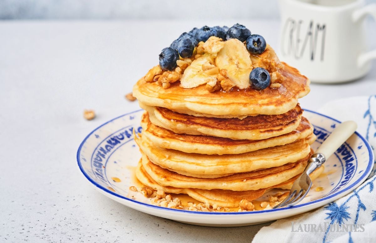 plate of pancakes topped with bananas and blueberries