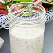 a jar of cottage cheese ranch dressing, next to a salad