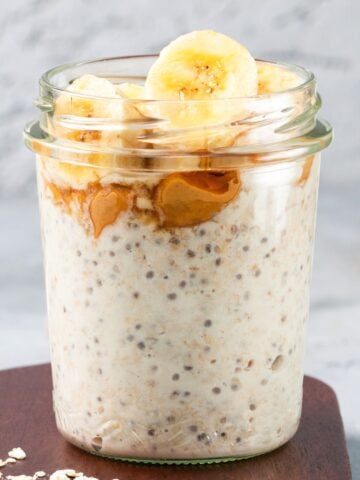a jar of overnight oats with chia seeds topped with banana slices