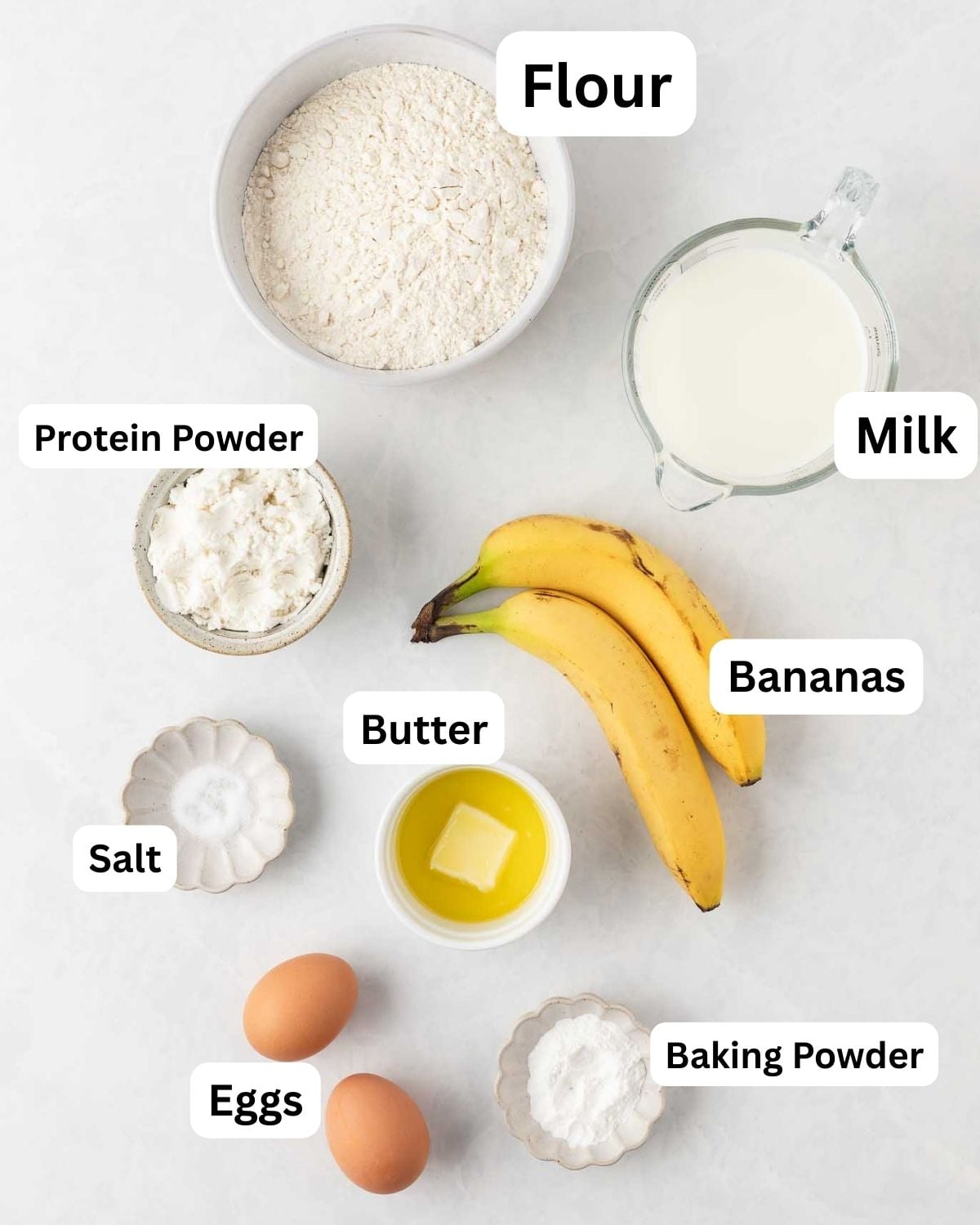 overhead view of ingredients to make banana protein powder pancakes (all ingredients labeled)