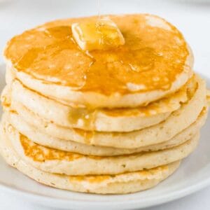 stack of pancakes topped with butter and syrup