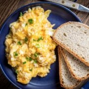top view of a blue dish with scrambled eggs and toast