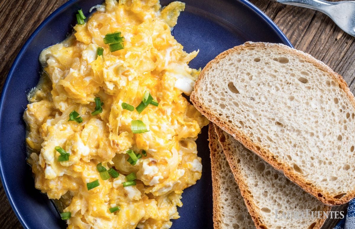 top view of a blue dish with scrambled eggs and toast