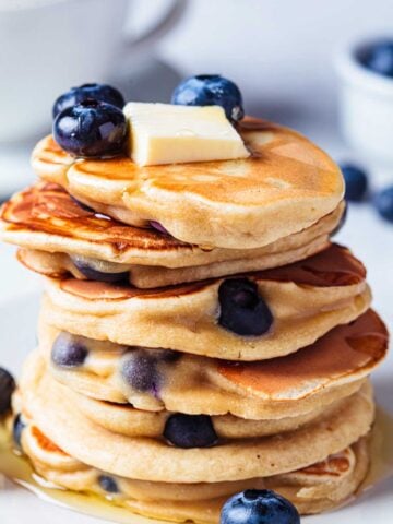 stack of blueberry pancakes topped with butter