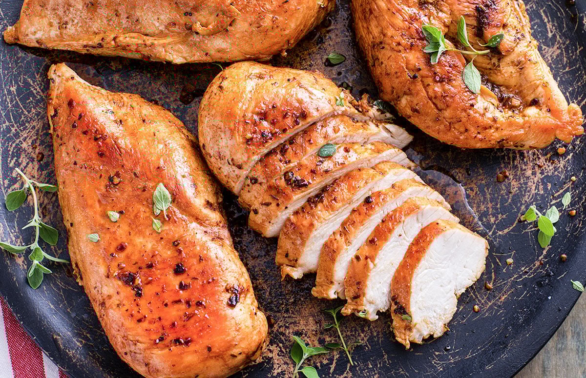 top view of four chipotle chicken breasts, one of them sliced