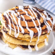 three cinnamon roll pancakes on a plate