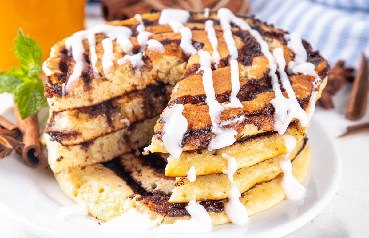 stack of cinnamon roll pancakes with one bite cut out