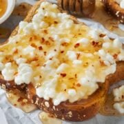 a piece of toast with cottage cheese and hot honey