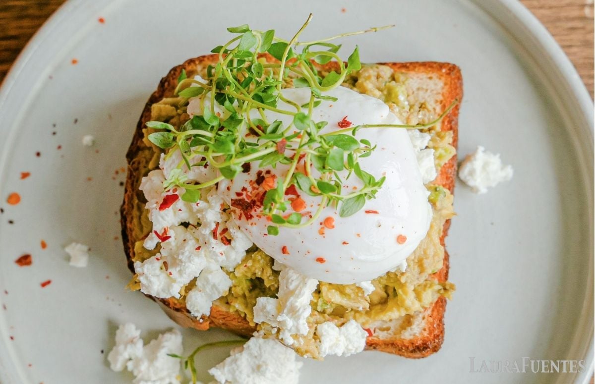 top view of a piece of toast with cottage cheese, a soft egg and sprouts