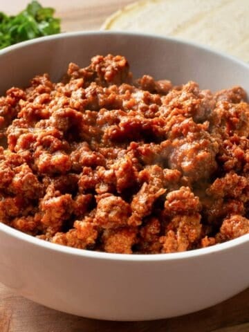 a bowl filled with taco meat cooked in a slow cooker