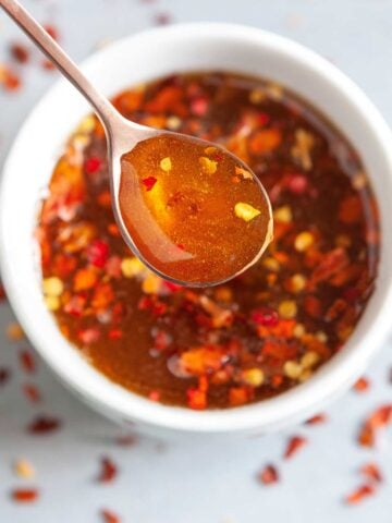 a spoonful of hot honey over a bowl with hot honey