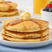 stack of homemade IHOP pancakes on a white plate topped with butter and syrup
