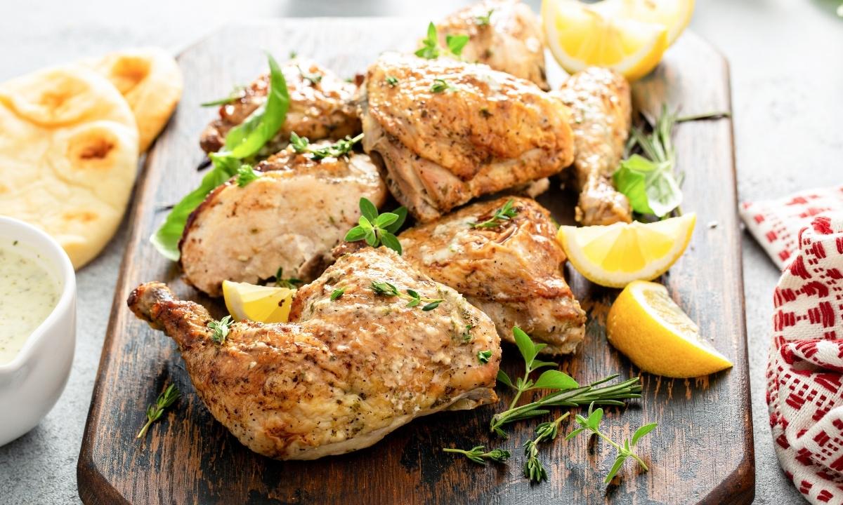 lemon herb chicken pieces over a wooden cutting board