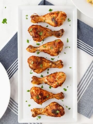 overhead view of baked chicken drumsticks on a platter