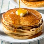 stack of buttermilk pancakes topped with butter and syrup