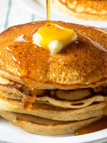 stack of buttermilk pancakes topped with butter and syrup