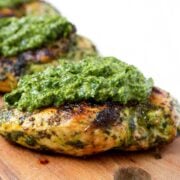 two chicken breasts with chimichurri sauce on top